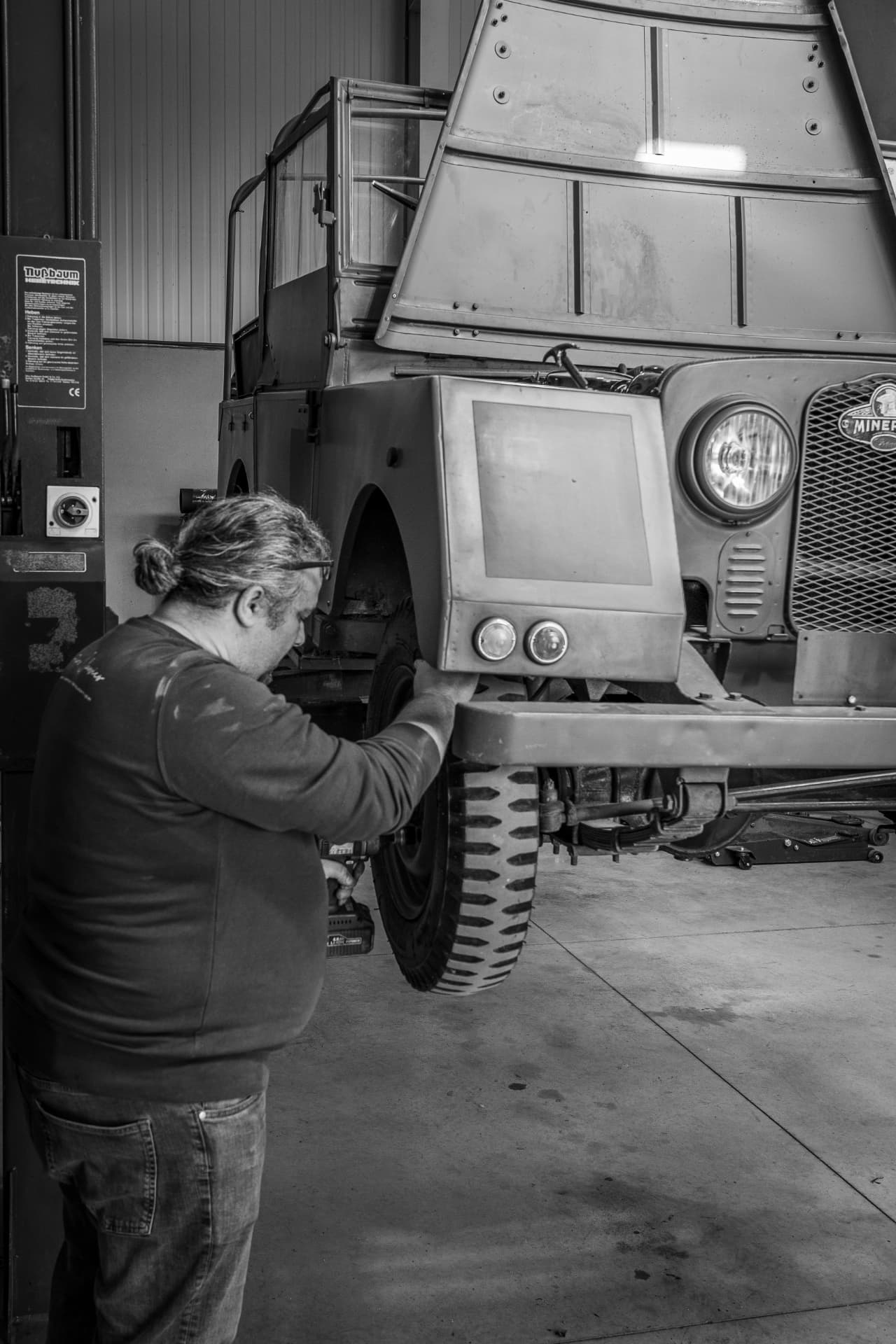 Minerva Land Rover sur pont élévateur en restauration